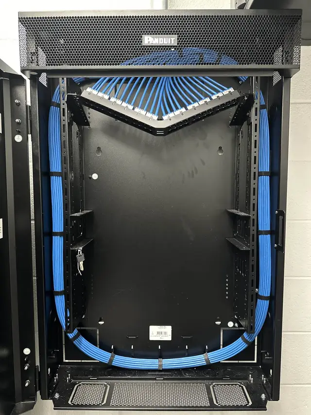V-shaped angled patch panel with blue Cat6A cables