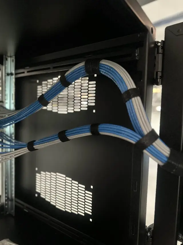 Blue and white cables bundled with velcro inside cabinet